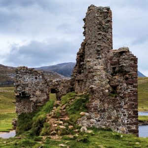 The ruins of Ardvreck Castle against the Highland hills.